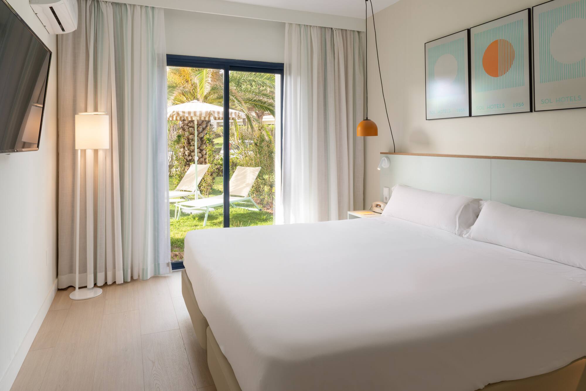 Spacious hotel room with king bed and direct garden patio access.