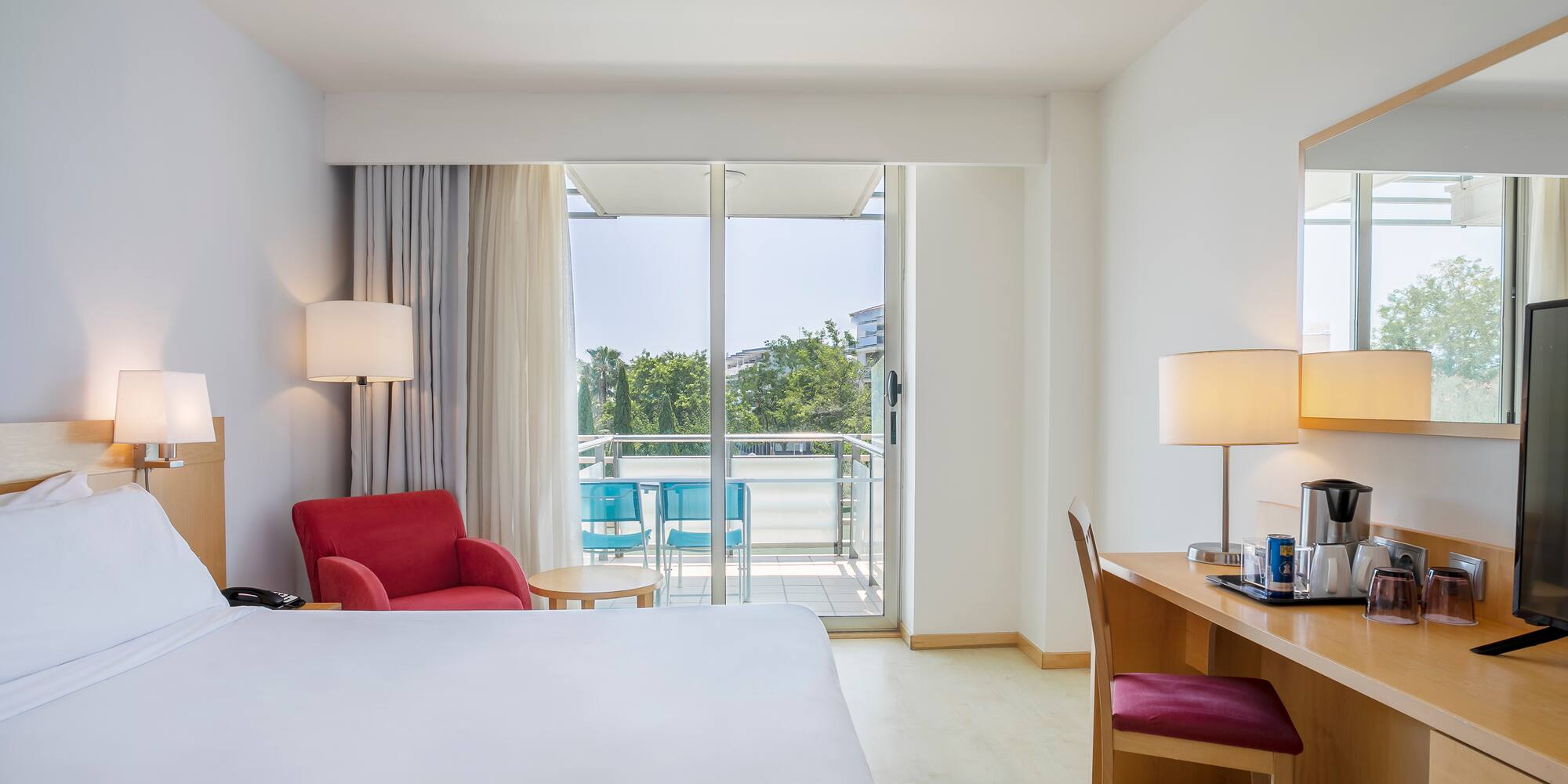 a room with a bed and a desk and chairs