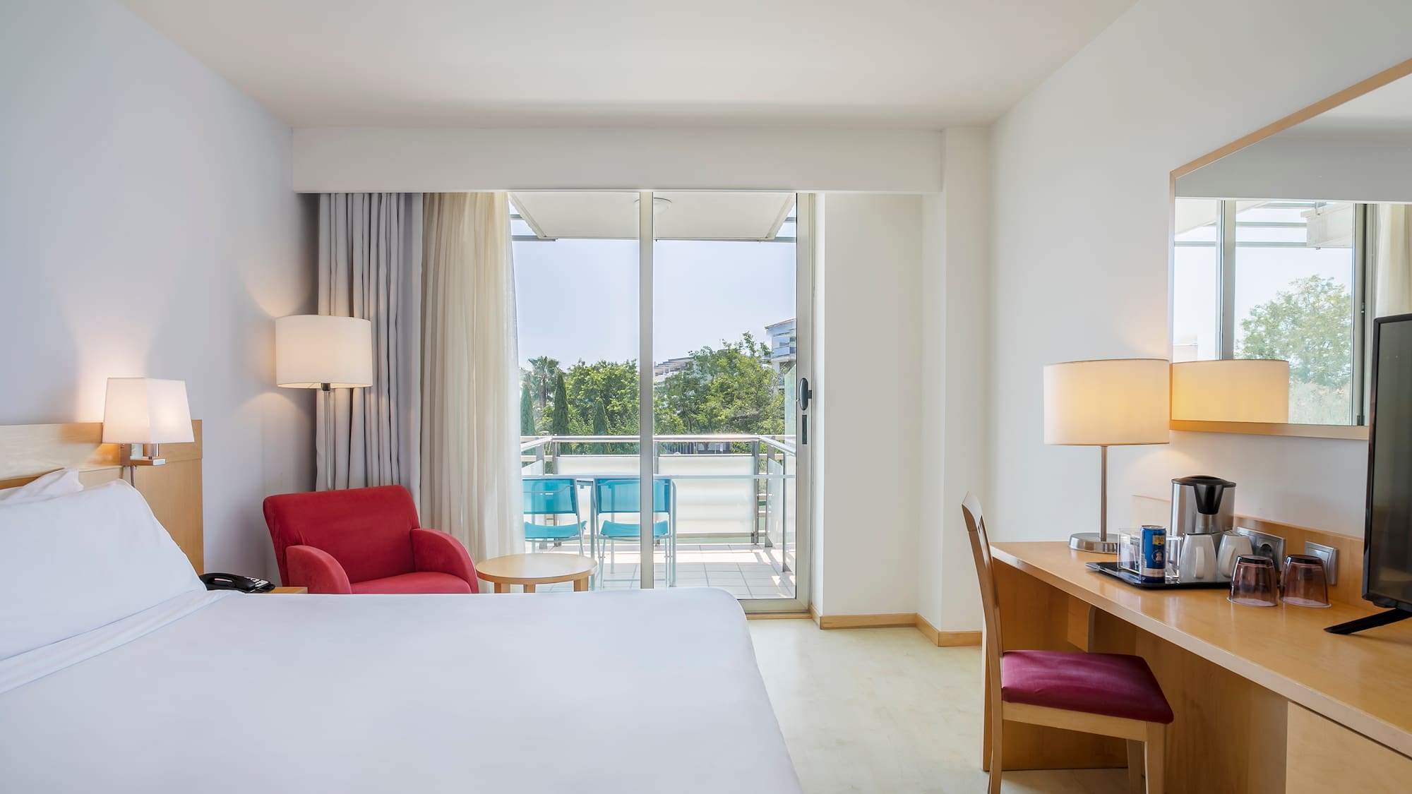 a room with a bed and a desk and chairs