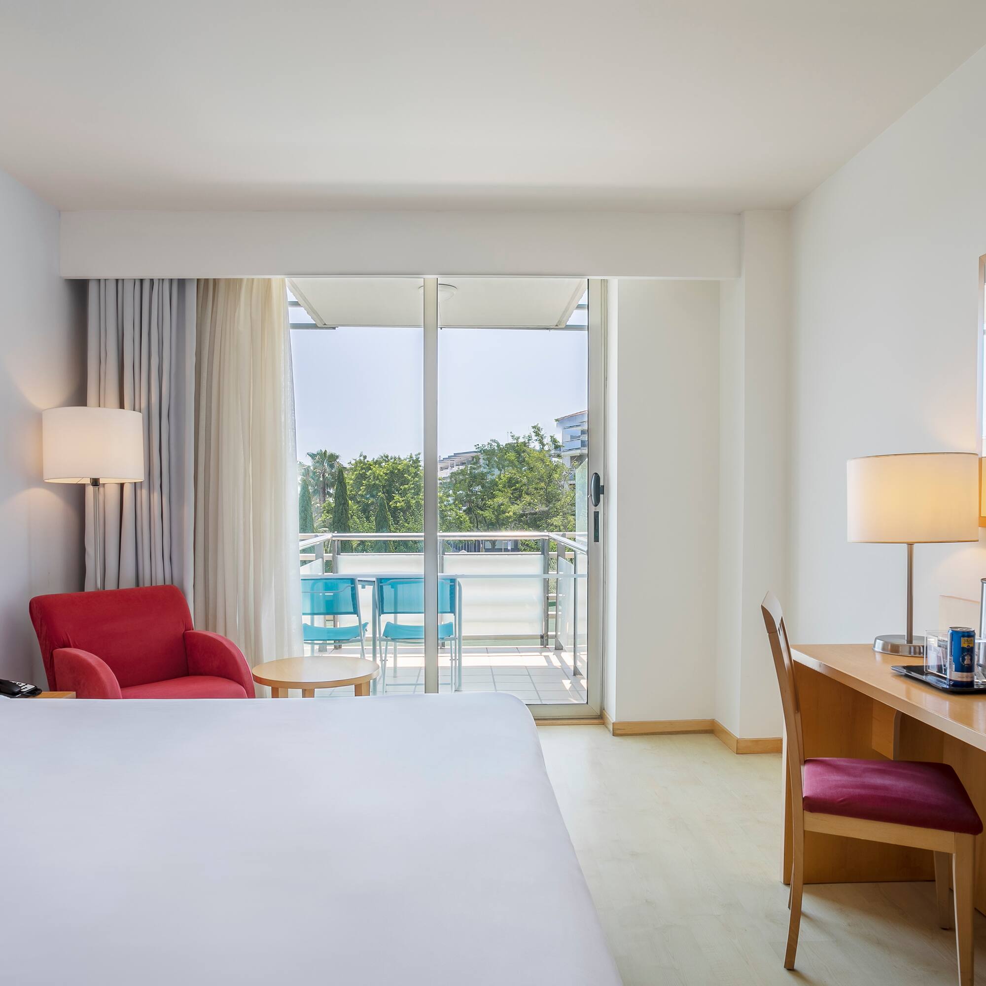 a room with a bed and a desk and chairs