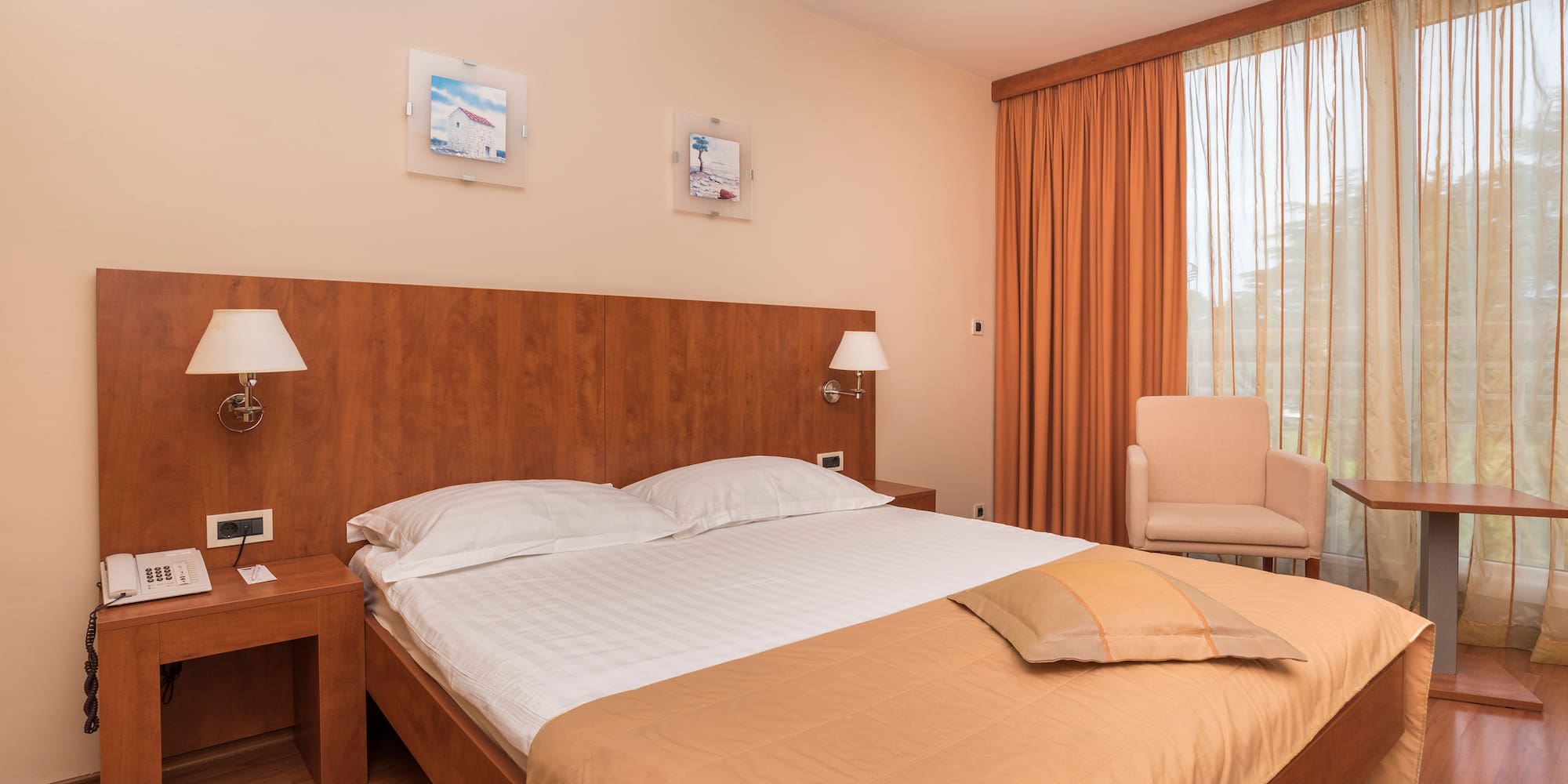 a bed with a wood headboard and a chair in a room