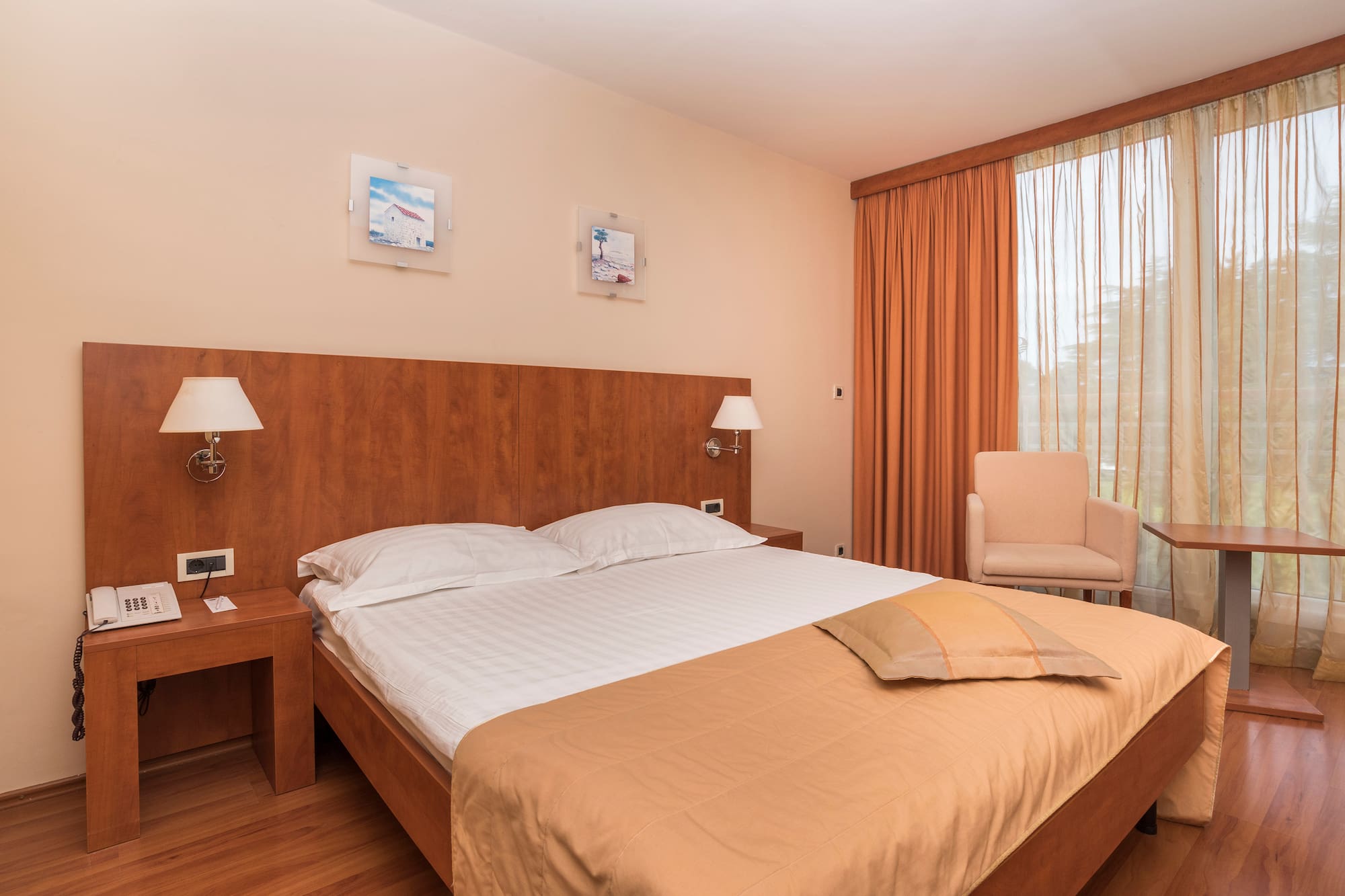 a bed with a wood headboard and a chair in a room