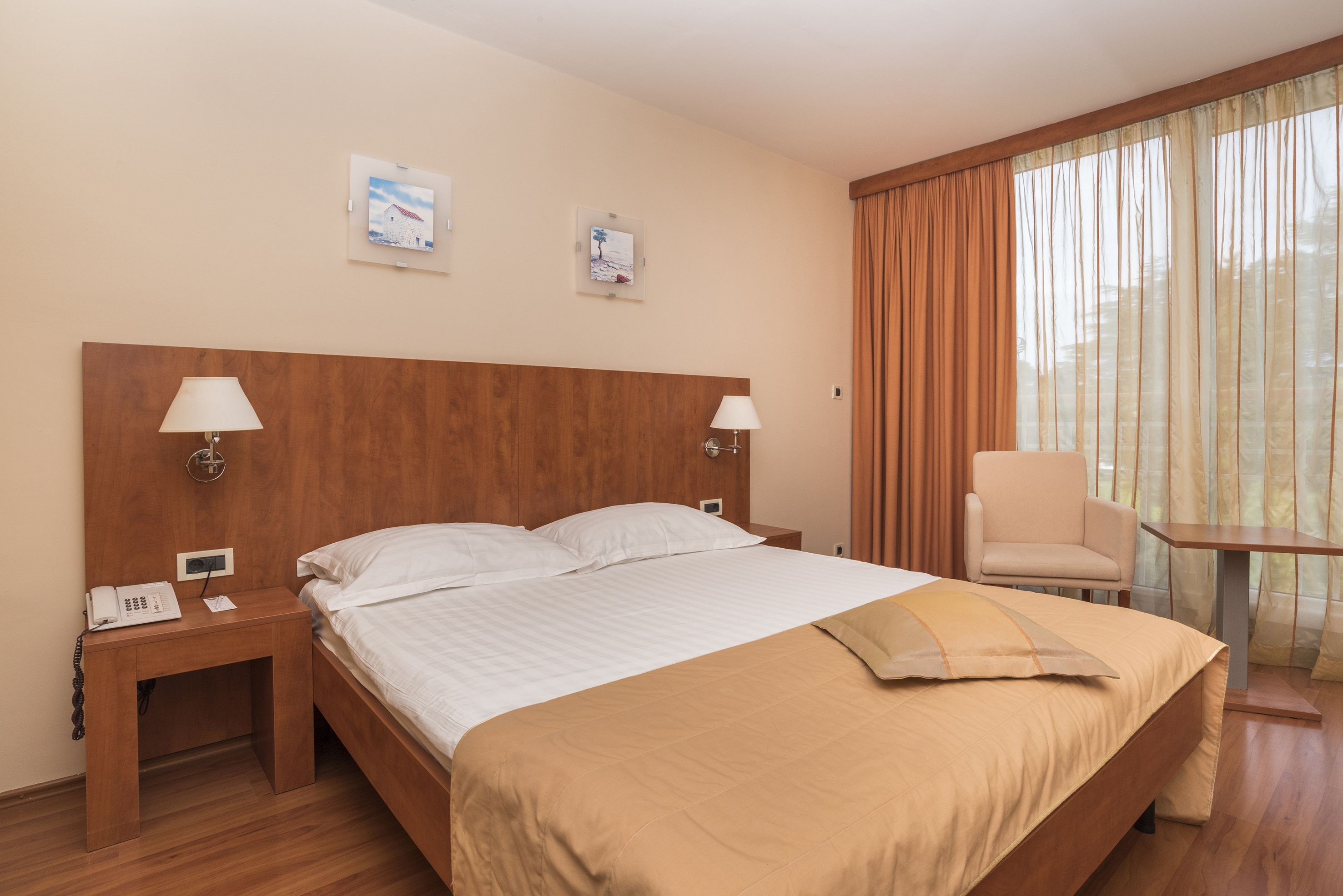 a bed with a wood headboard and a chair in a room