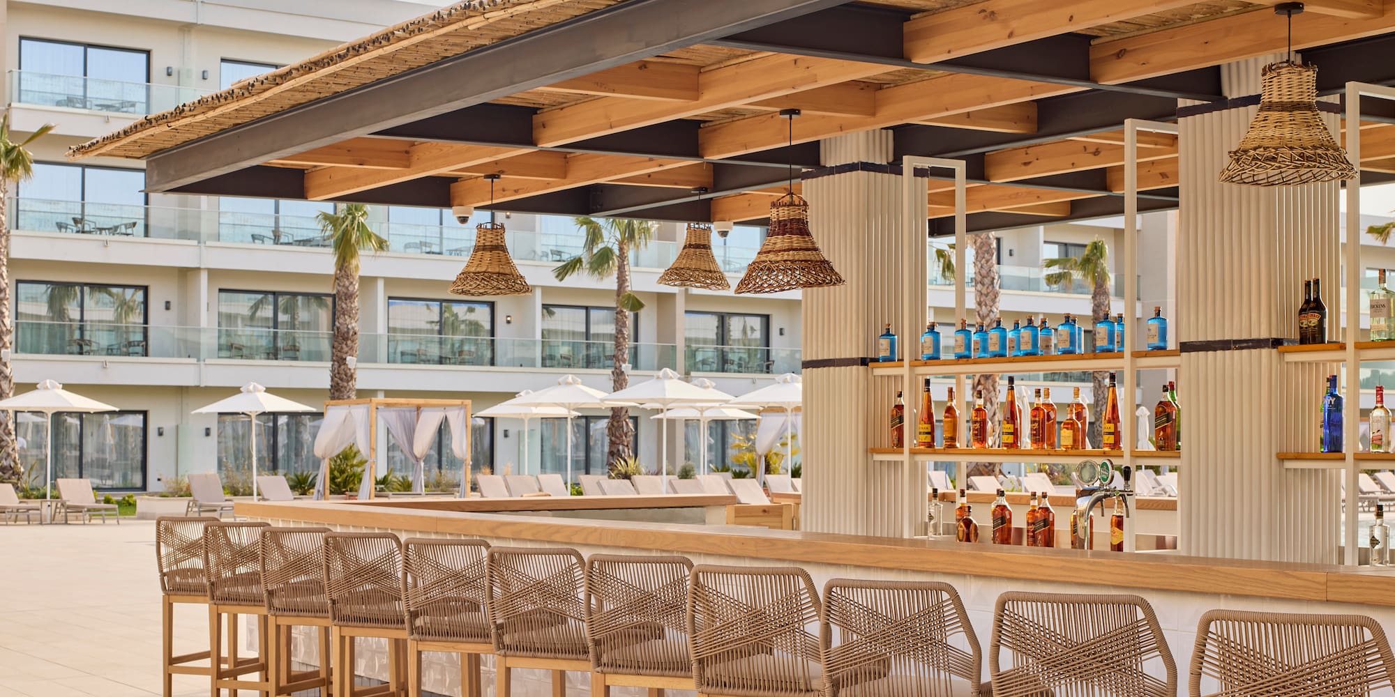 a bar with chairs and bottles of alcohol