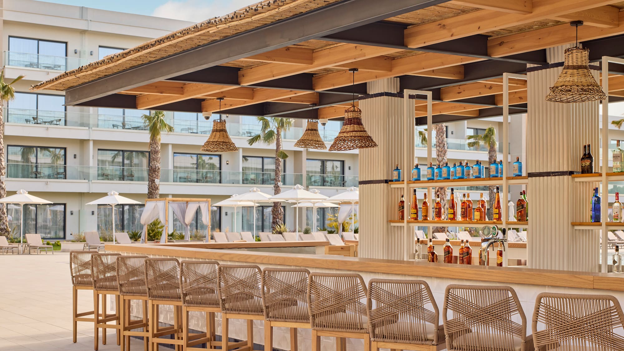 a bar with chairs and bottles of alcohol