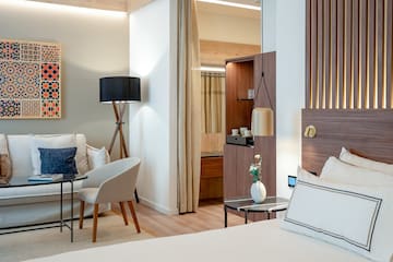 a room with a bed and a table and chairs