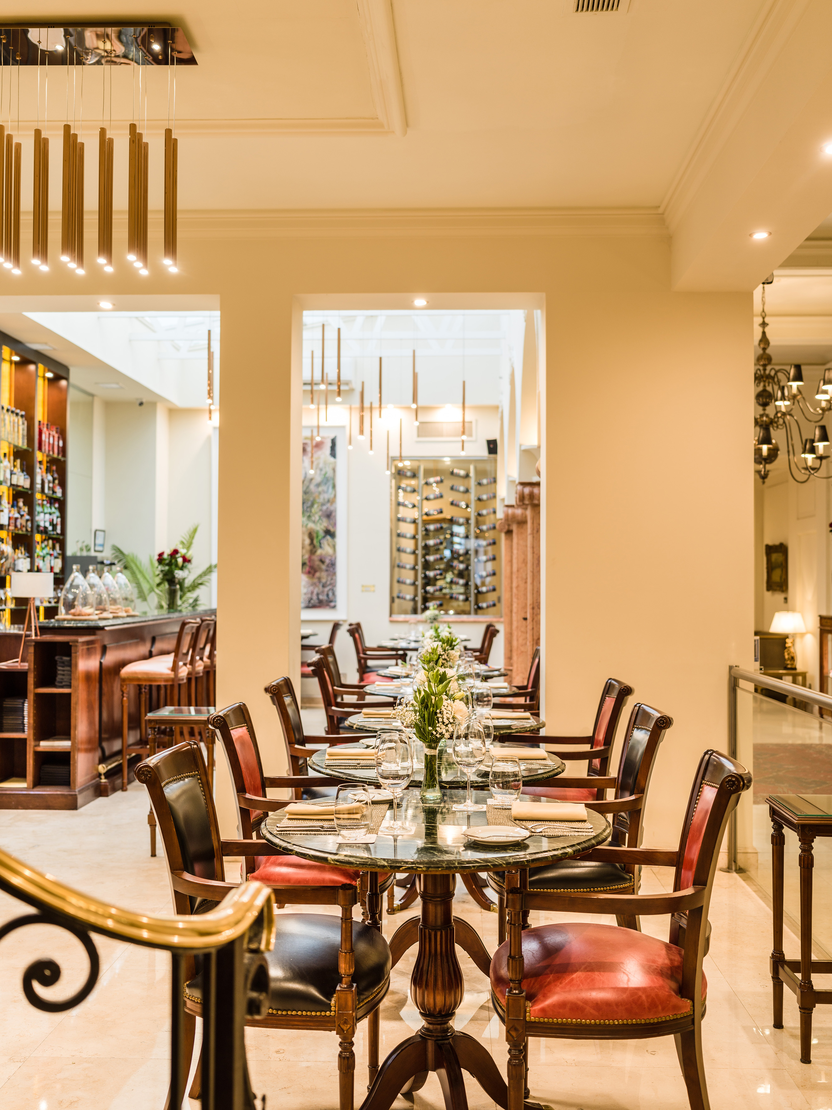 Elegant restaurant dining room with set tables, bar, and wine cellar.