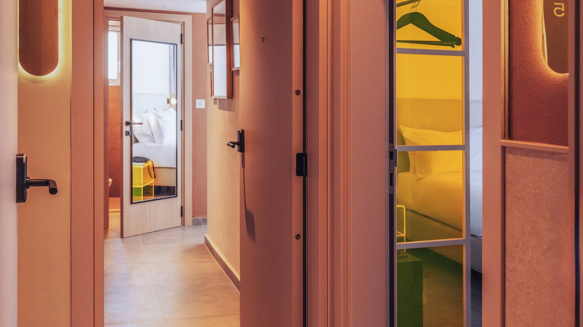 a hallway with a door open and a mirror