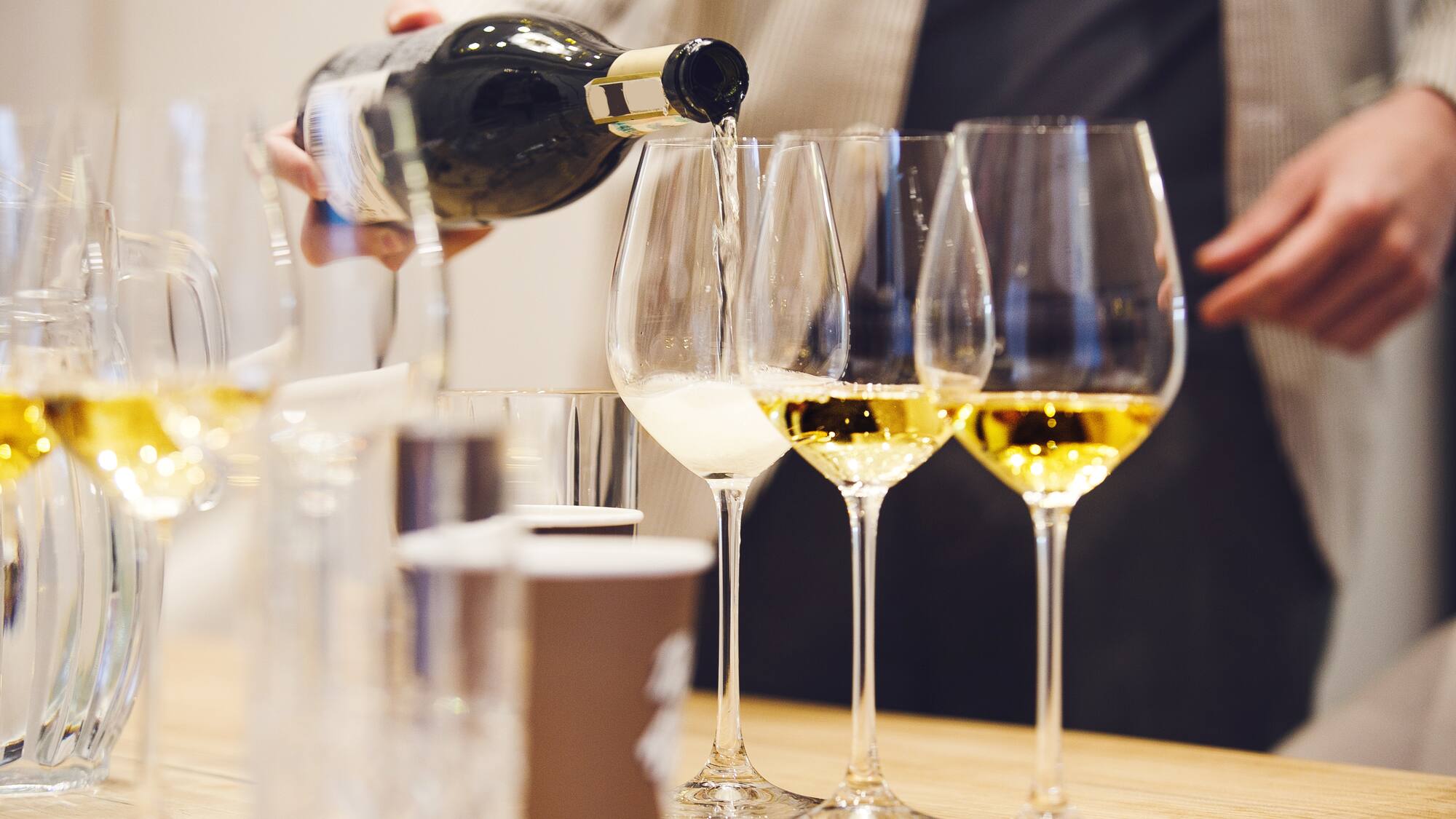 a person pouring wine into a glass