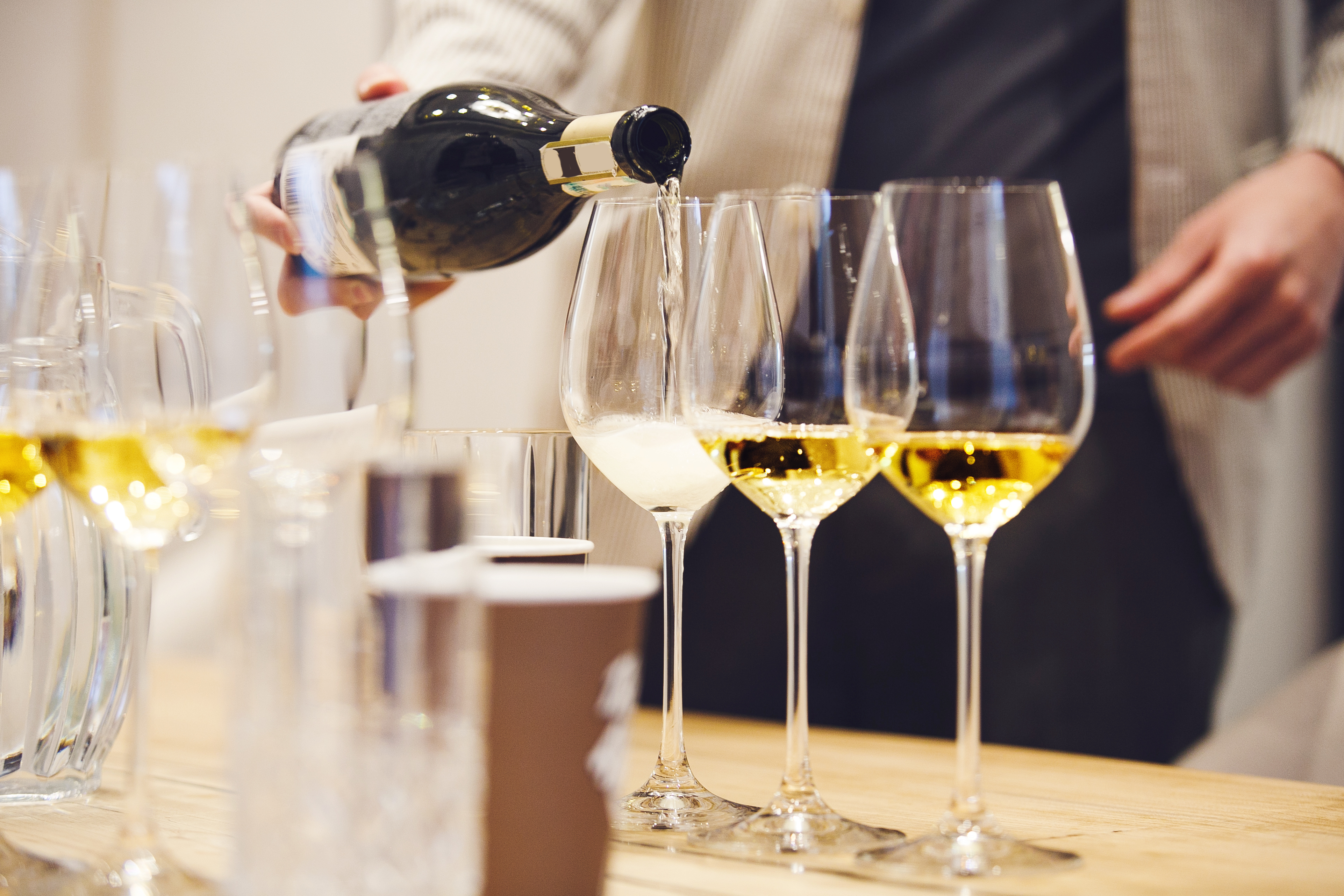 a person pouring wine into a glass