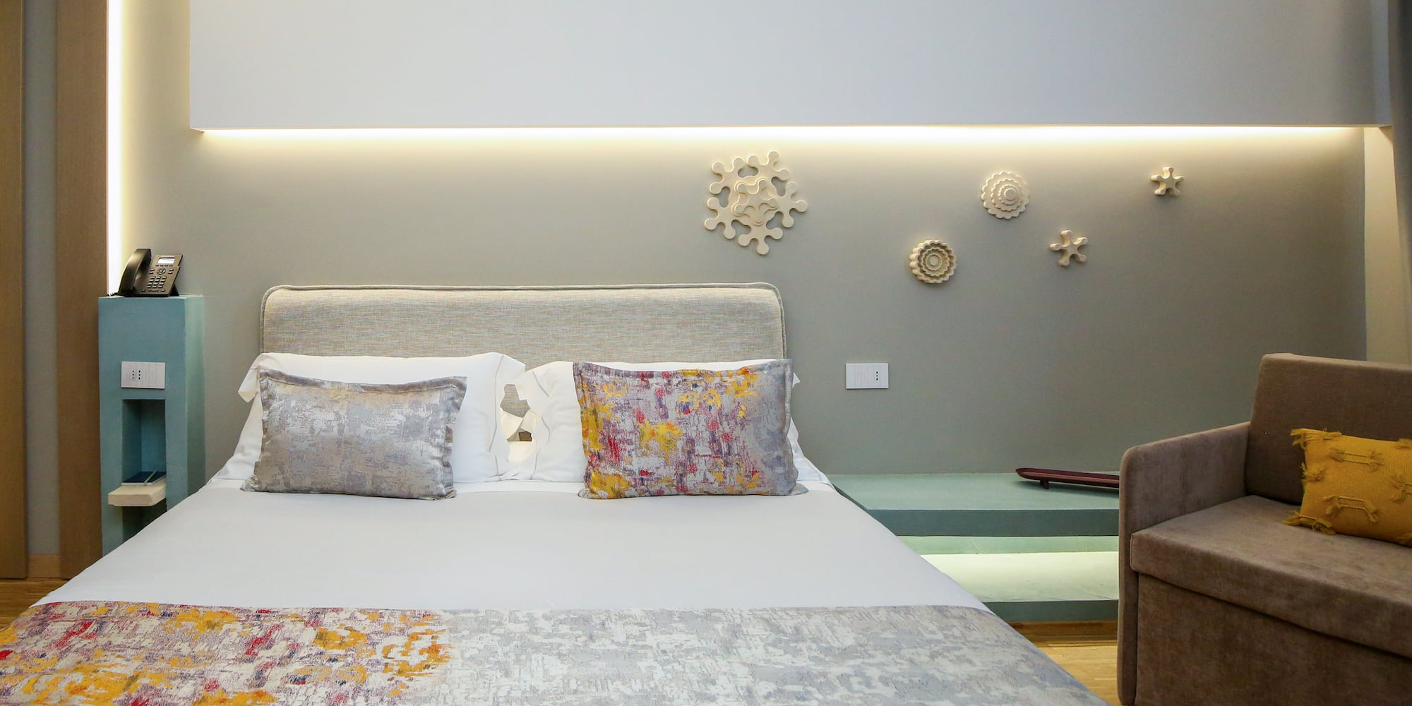 a bed with pillows and a couch in a room