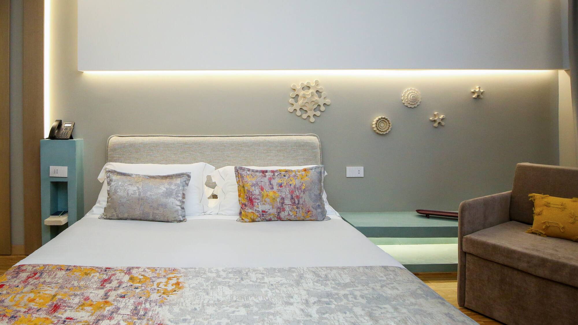 a bed with pillows and a couch in a room