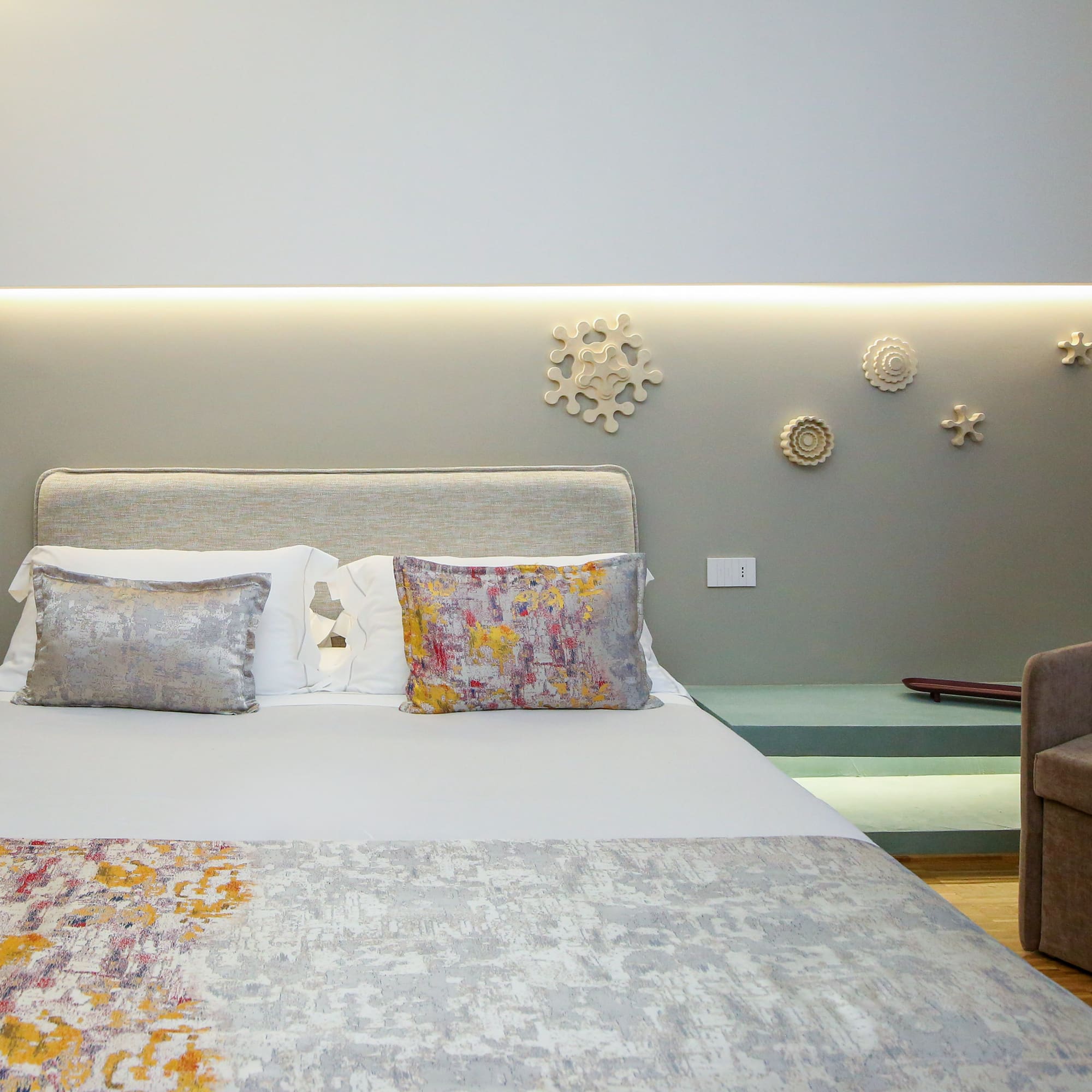 a bed with pillows and a couch in a room