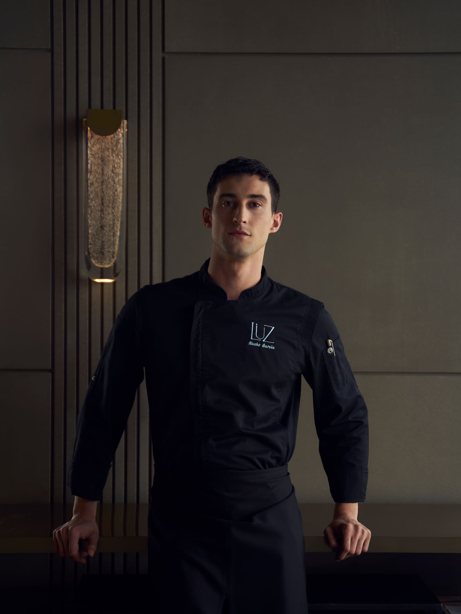 a man wearing a black chef's uniform