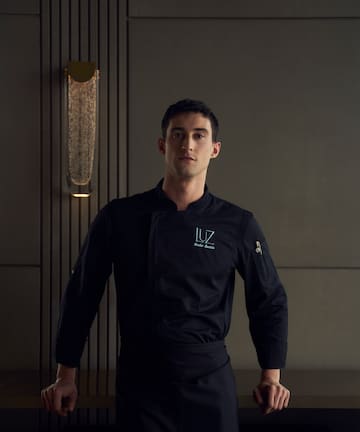 a man wearing a black chef's uniform