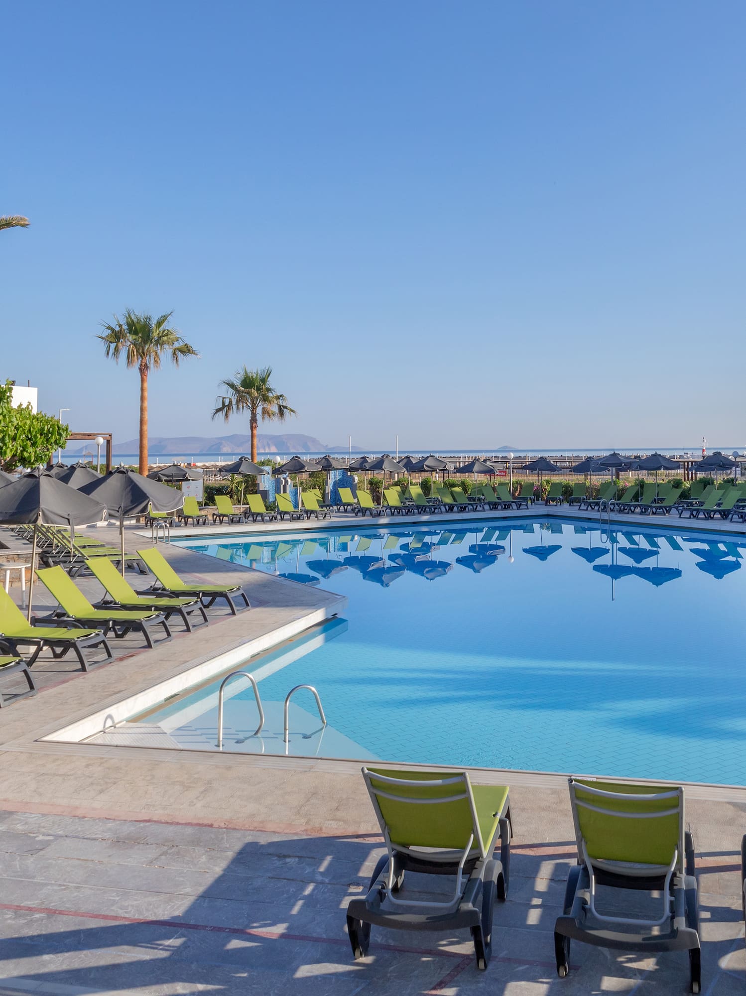 a pool with lounge chairs and umbrellas