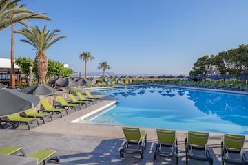 a pool with lounge chairs and umbrellas