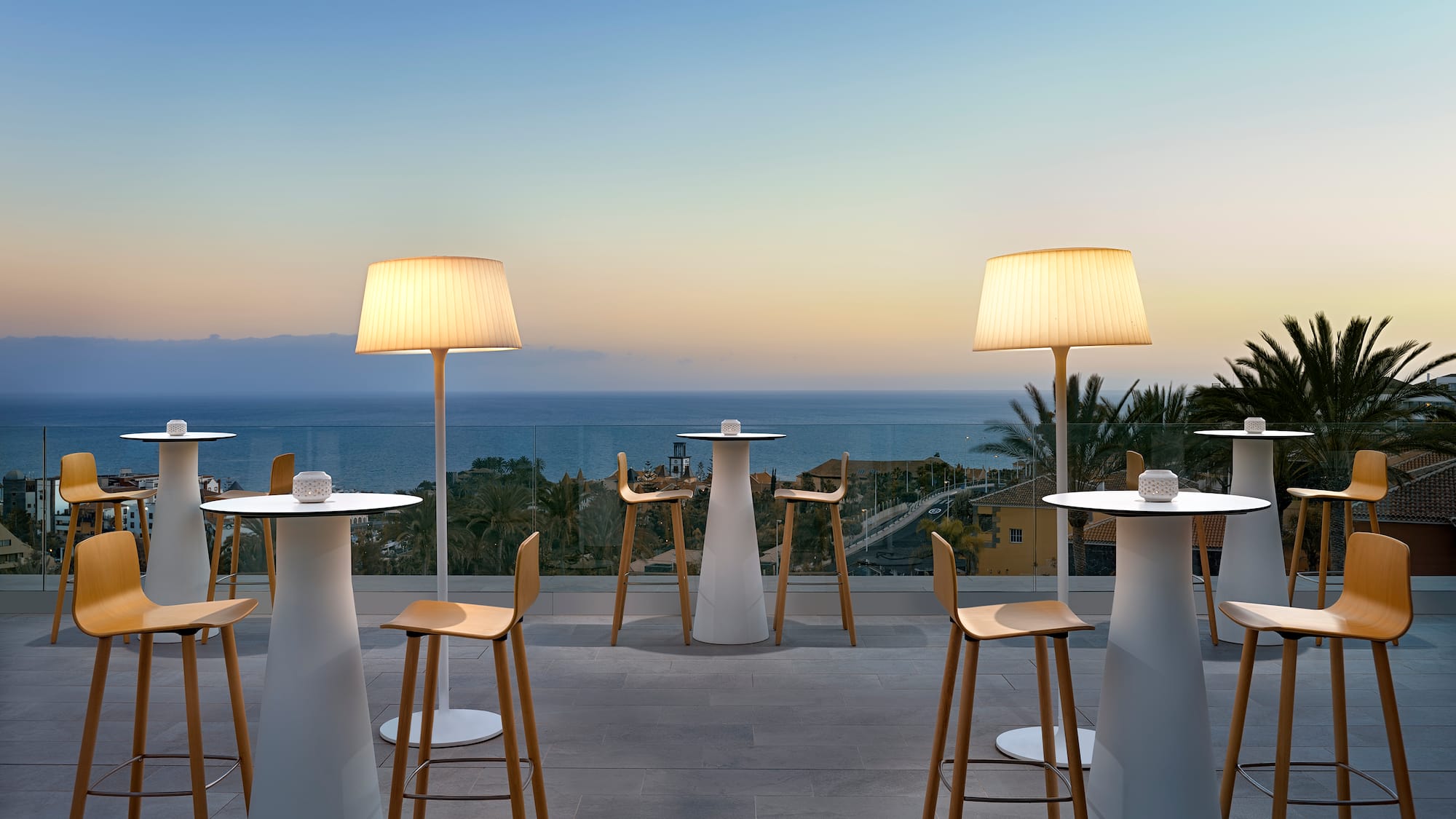 a group of tables and chairs with a view of the ocean