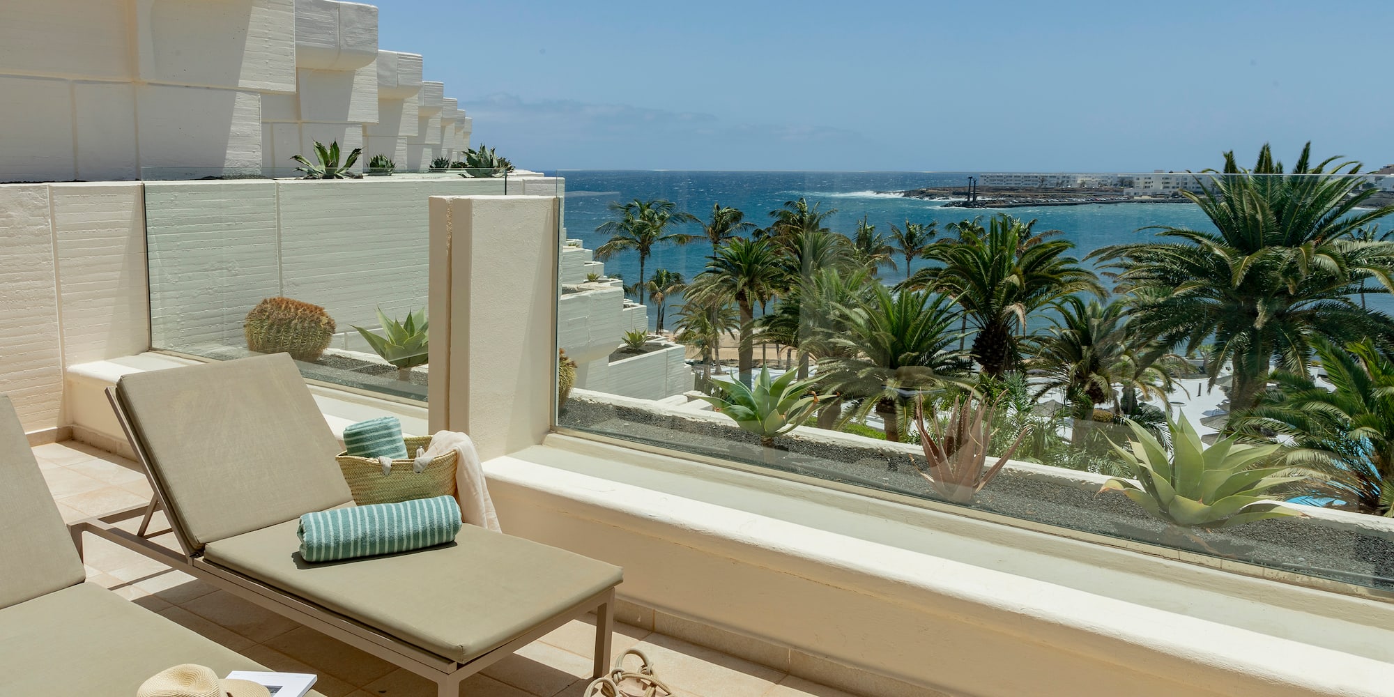a lounge chair on a balcony overlooking a body of water