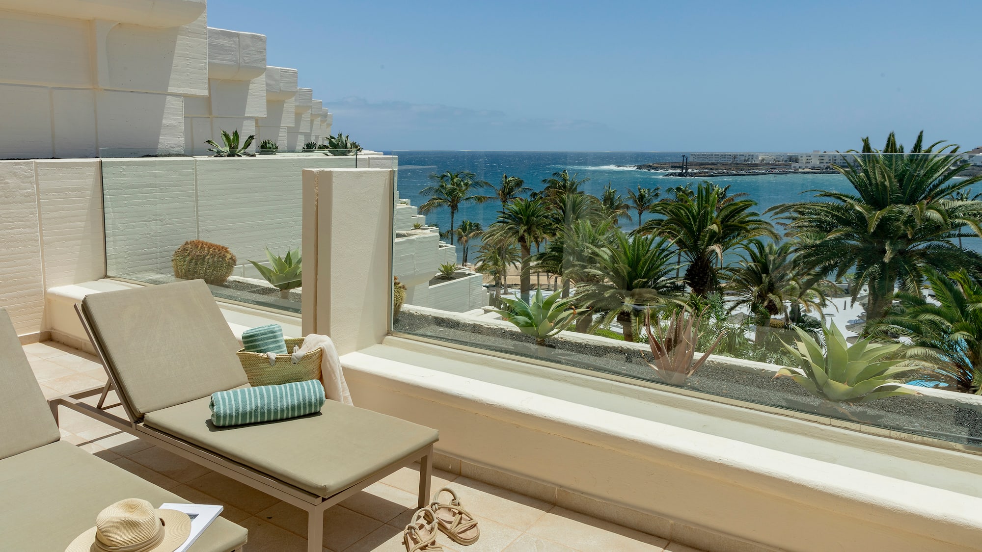 a lounge chair on a balcony overlooking a body of water
