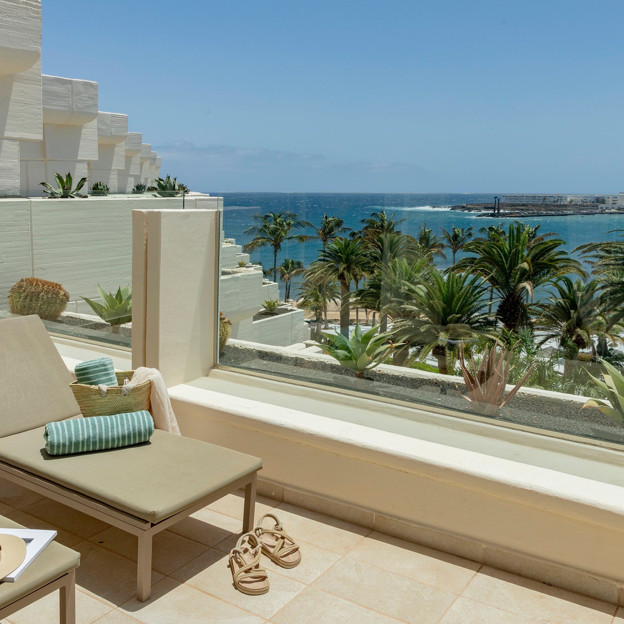 a lounge chair on a balcony overlooking a body of water