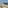 Sunny hotel balcony with ocean view, palm trees, and loungers.