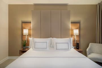 a bed with white sheets and pillows