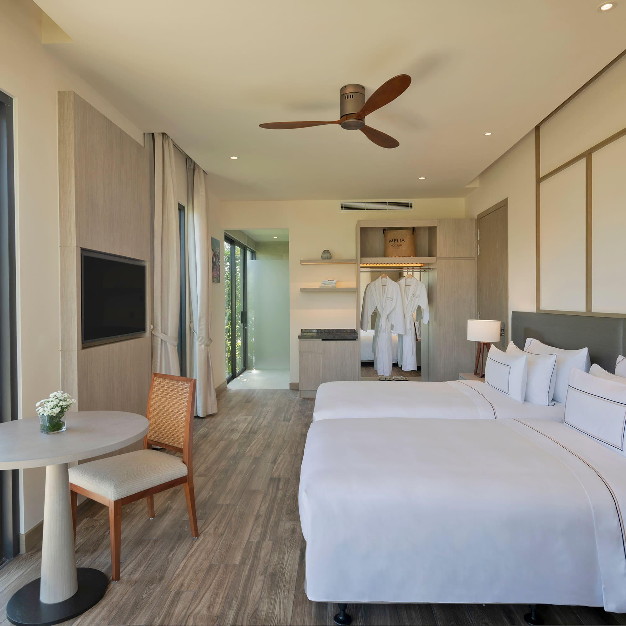 a room with two beds and a table and a tv