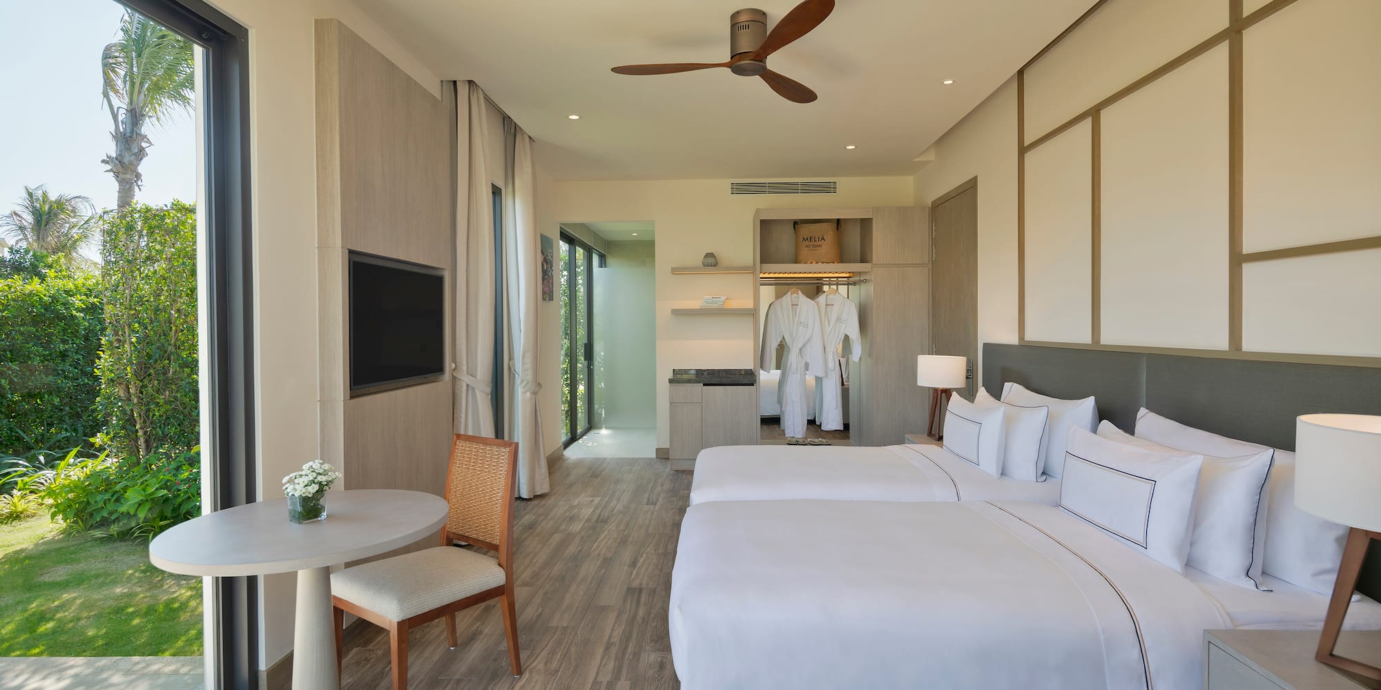 a room with two beds and a table and a tv