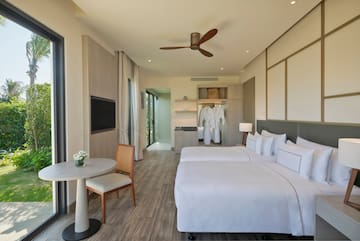 a room with two beds and a table and a tv