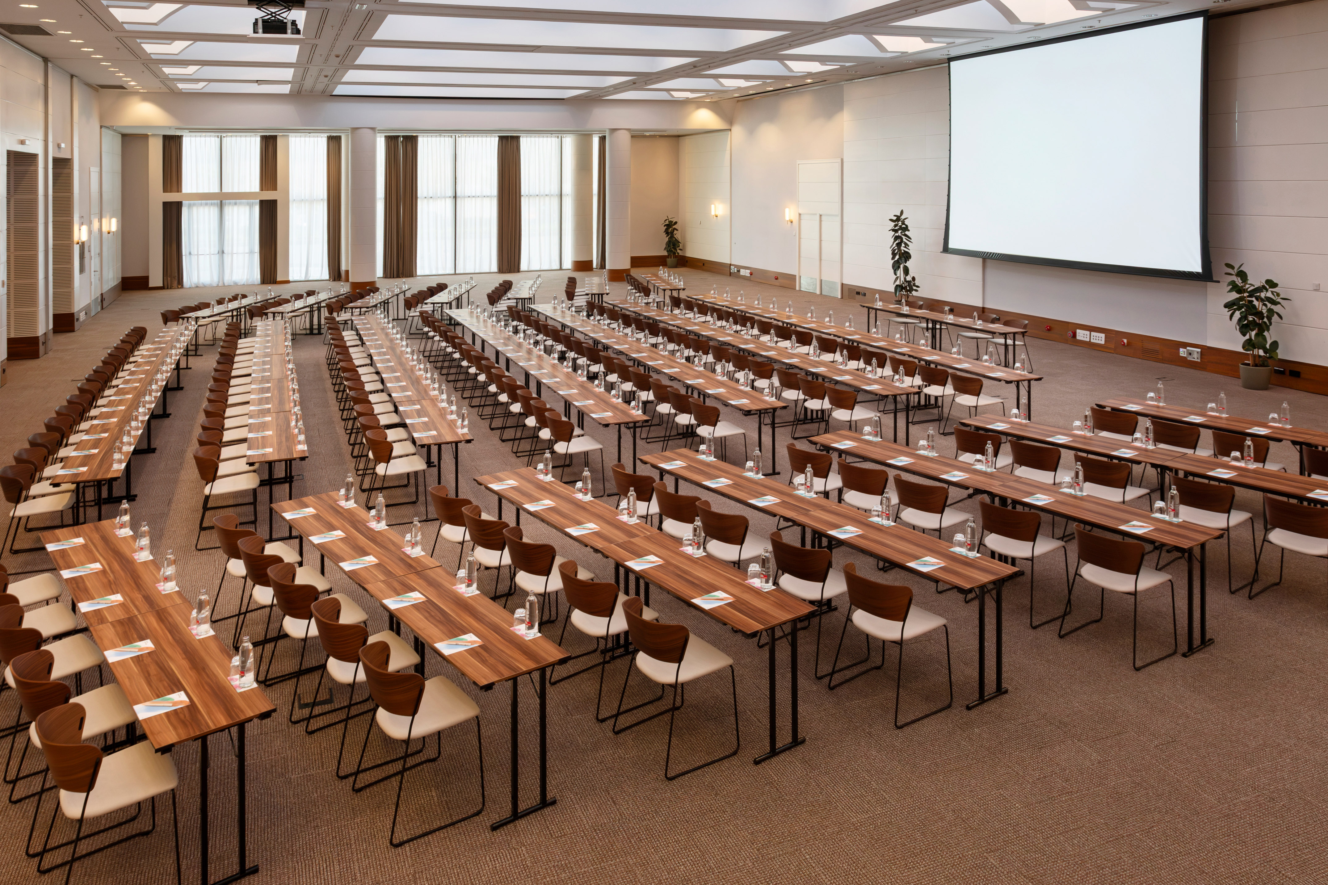 Large conference room with classroom setup and projection screen.