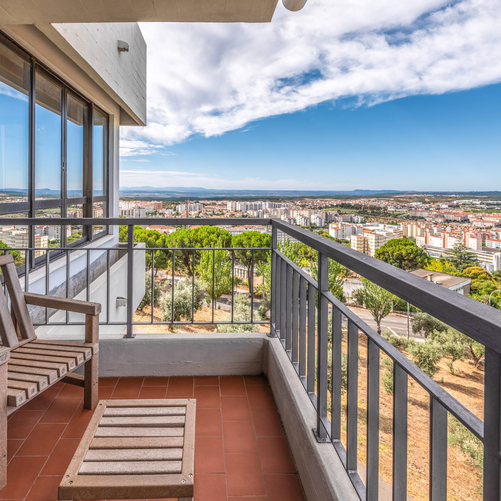 a balcony with a view of a city and a blue sky