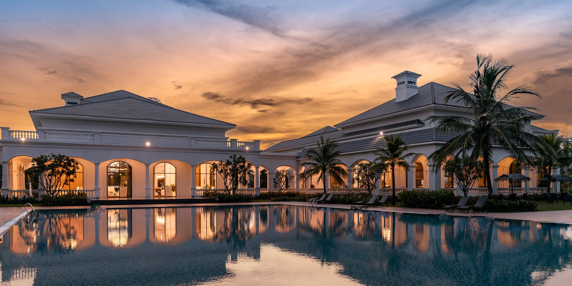 a pool with a building and palm trees