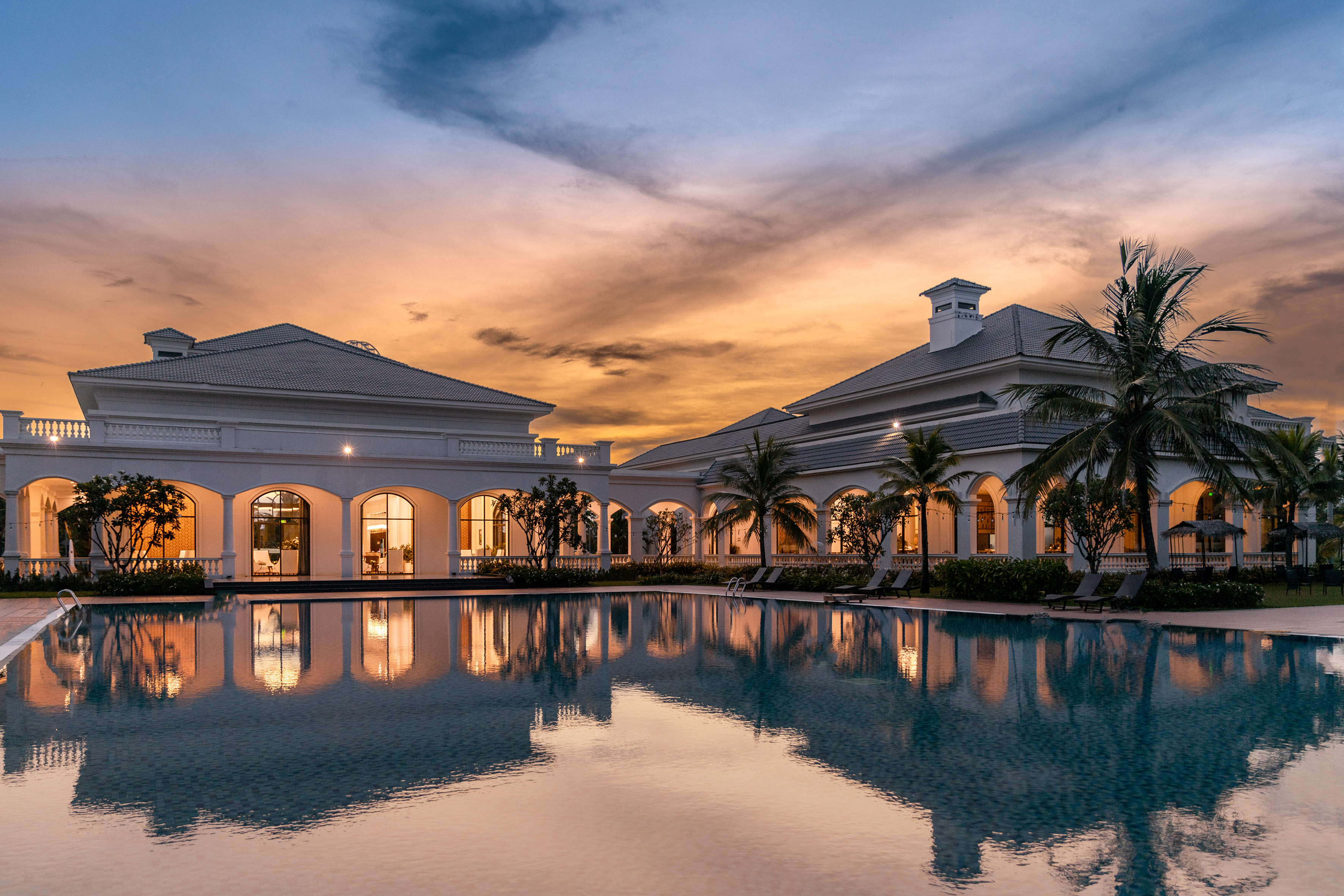 a pool with a building and palm trees