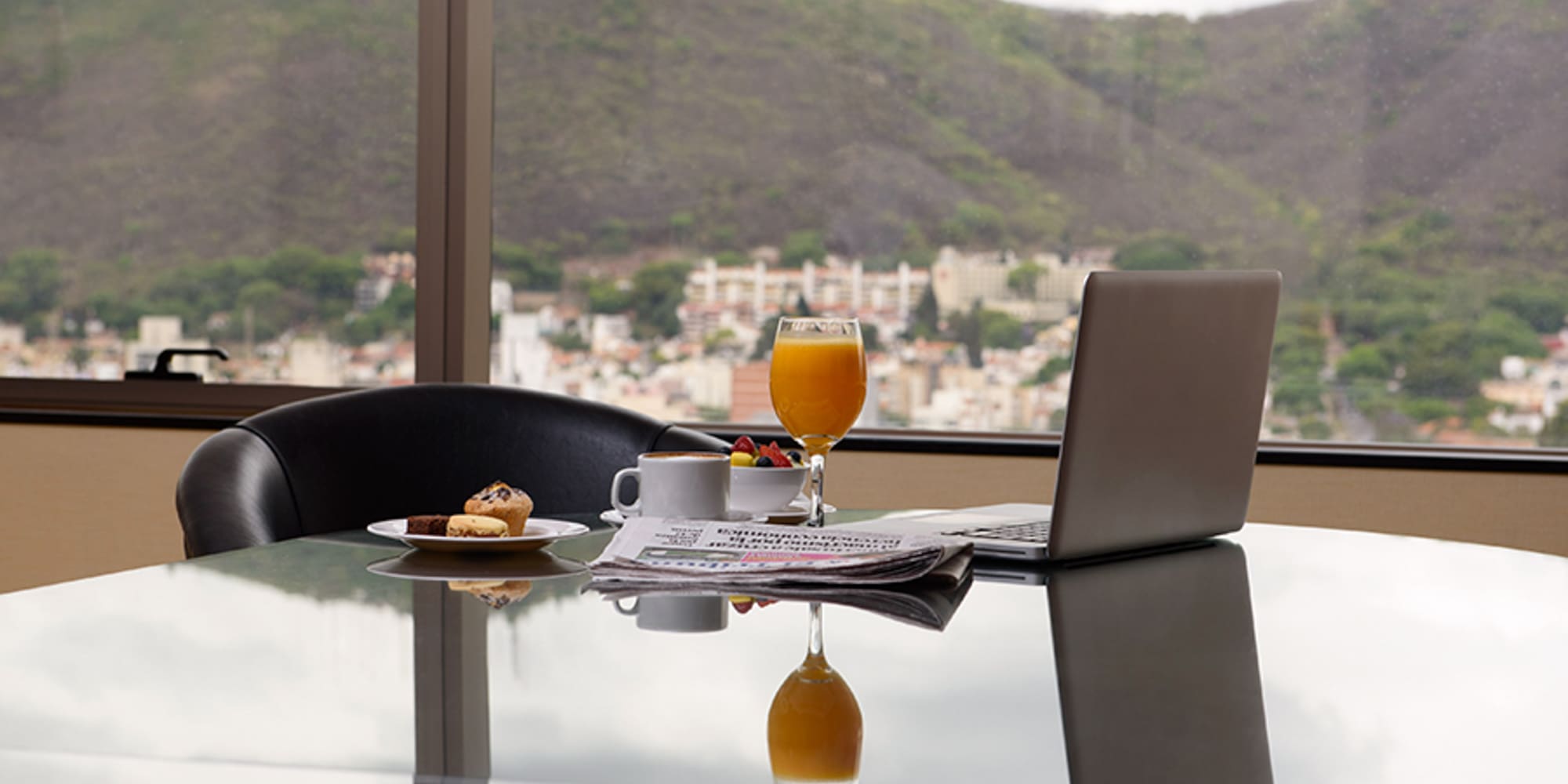 a laptop and a plate of food on a table