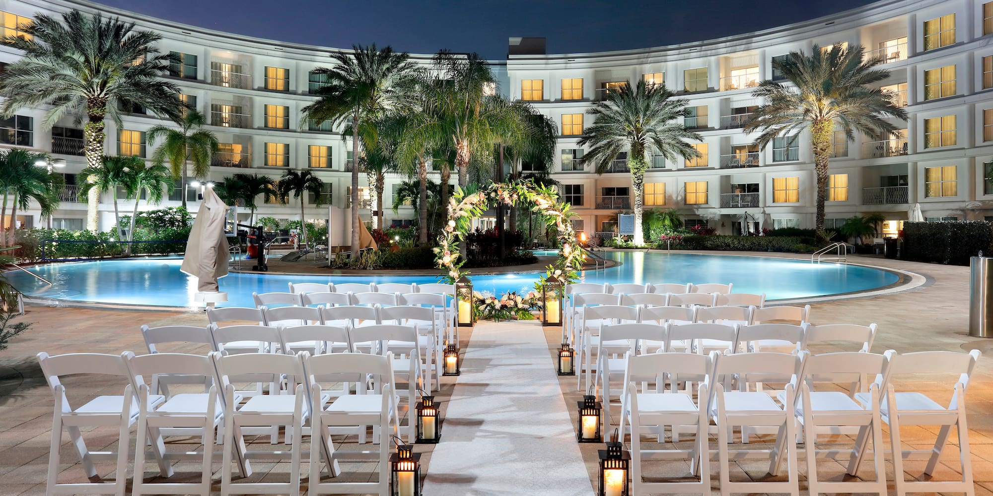 a wedding ceremony in front of a pool