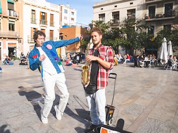 a man playing a saxophone next to a man in a blue jacket