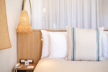 a bed with pillows and a lamp