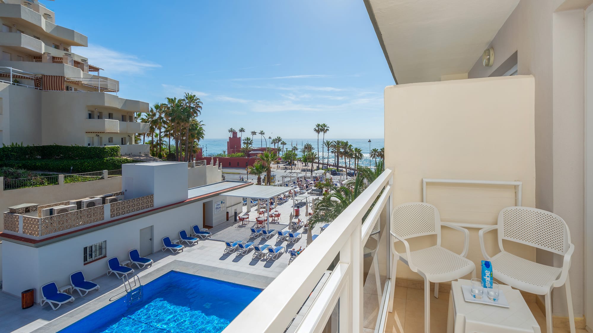 a balcony with chairs and a pool