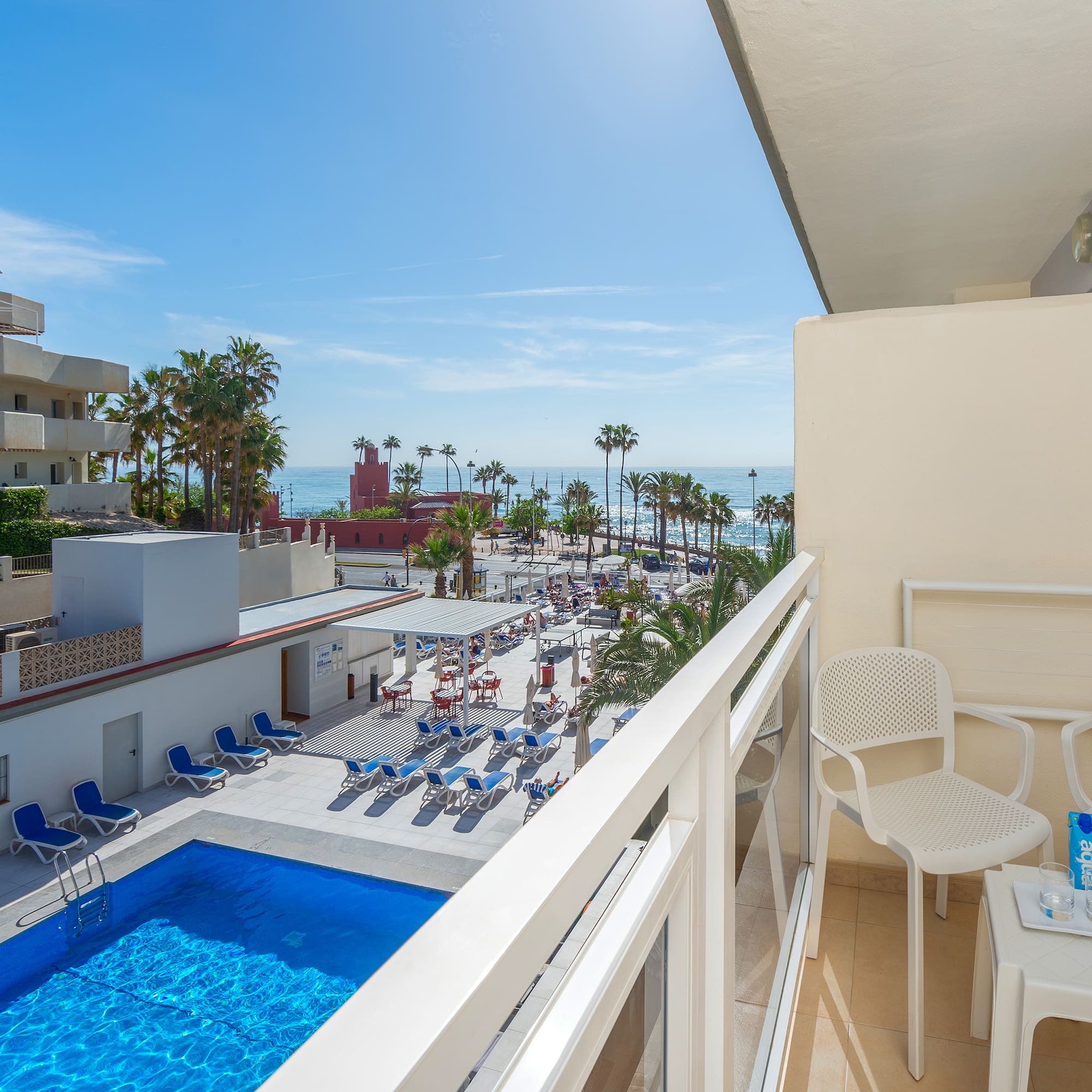 a balcony with chairs and a pool