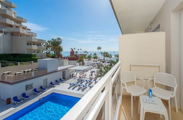 a balcony with chairs and a pool