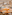 Spacious hotel buffet restaurant with wooden tables and woven chairs.