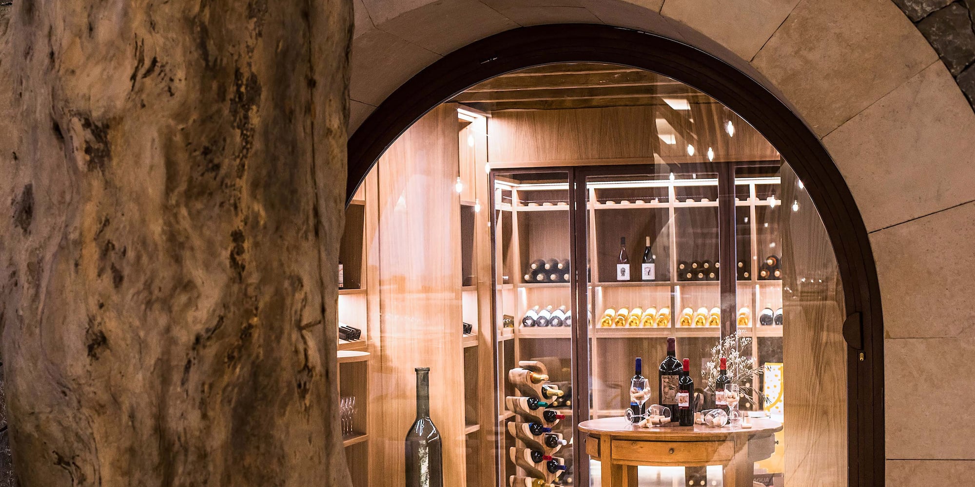 a wine cellar with a table and a bottle of wine