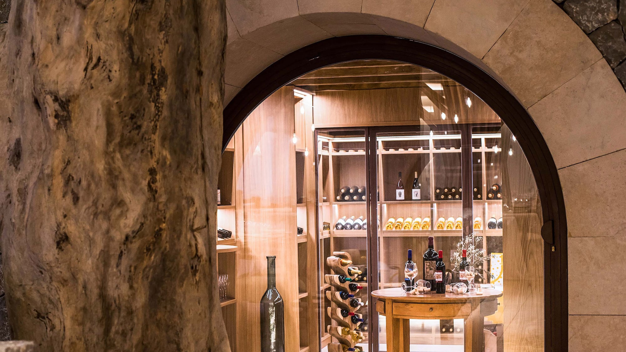 a wine cellar with a table and a bottle of wine