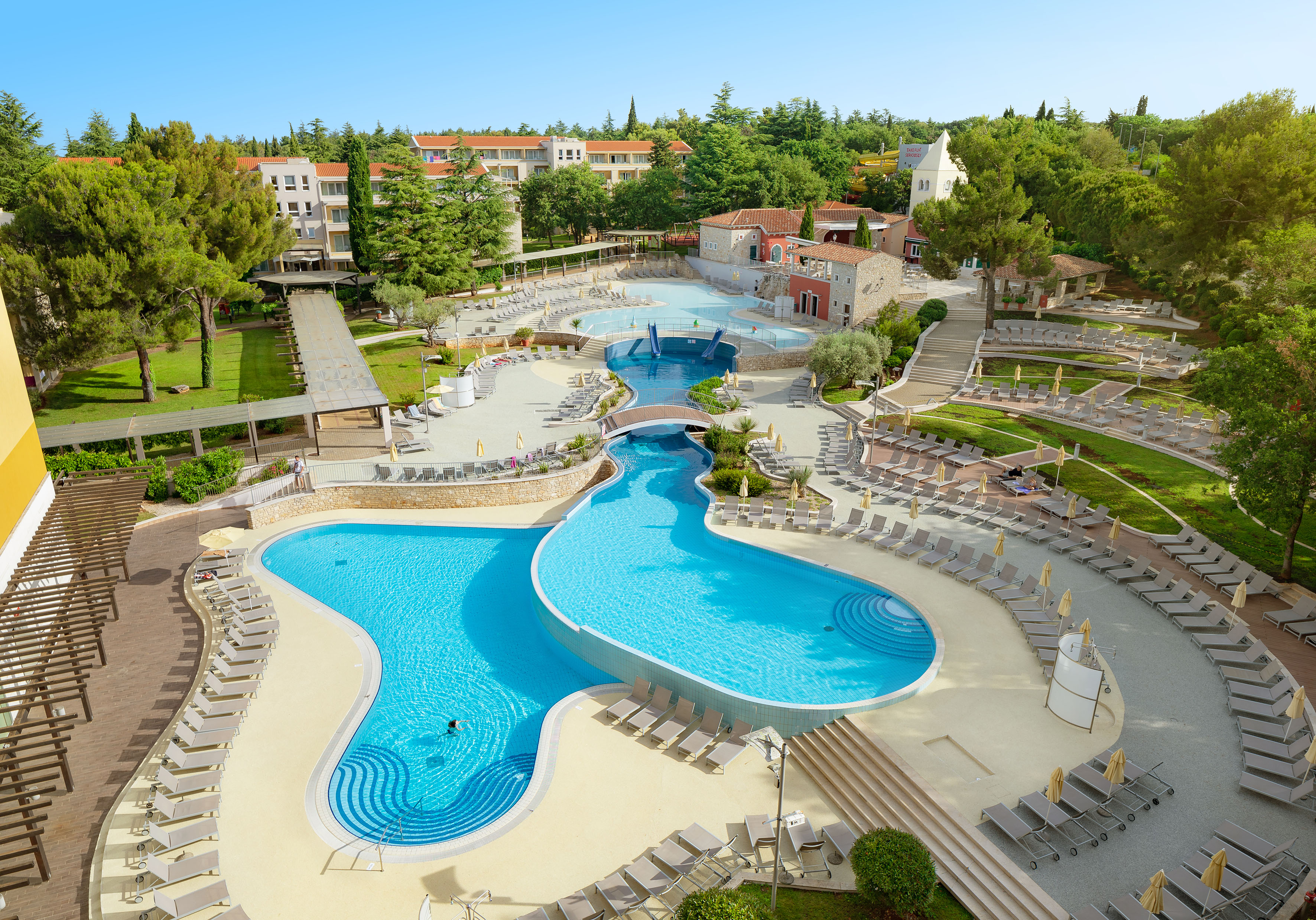 a swimming pool with chairs and trees