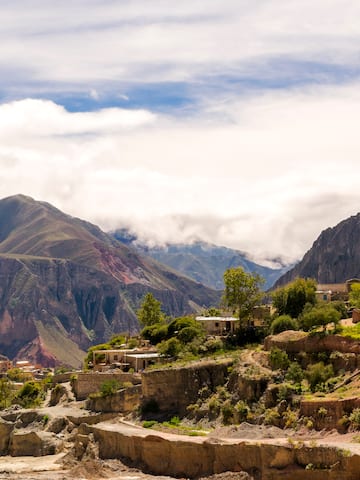 a town on a hillside with mountains in the background
