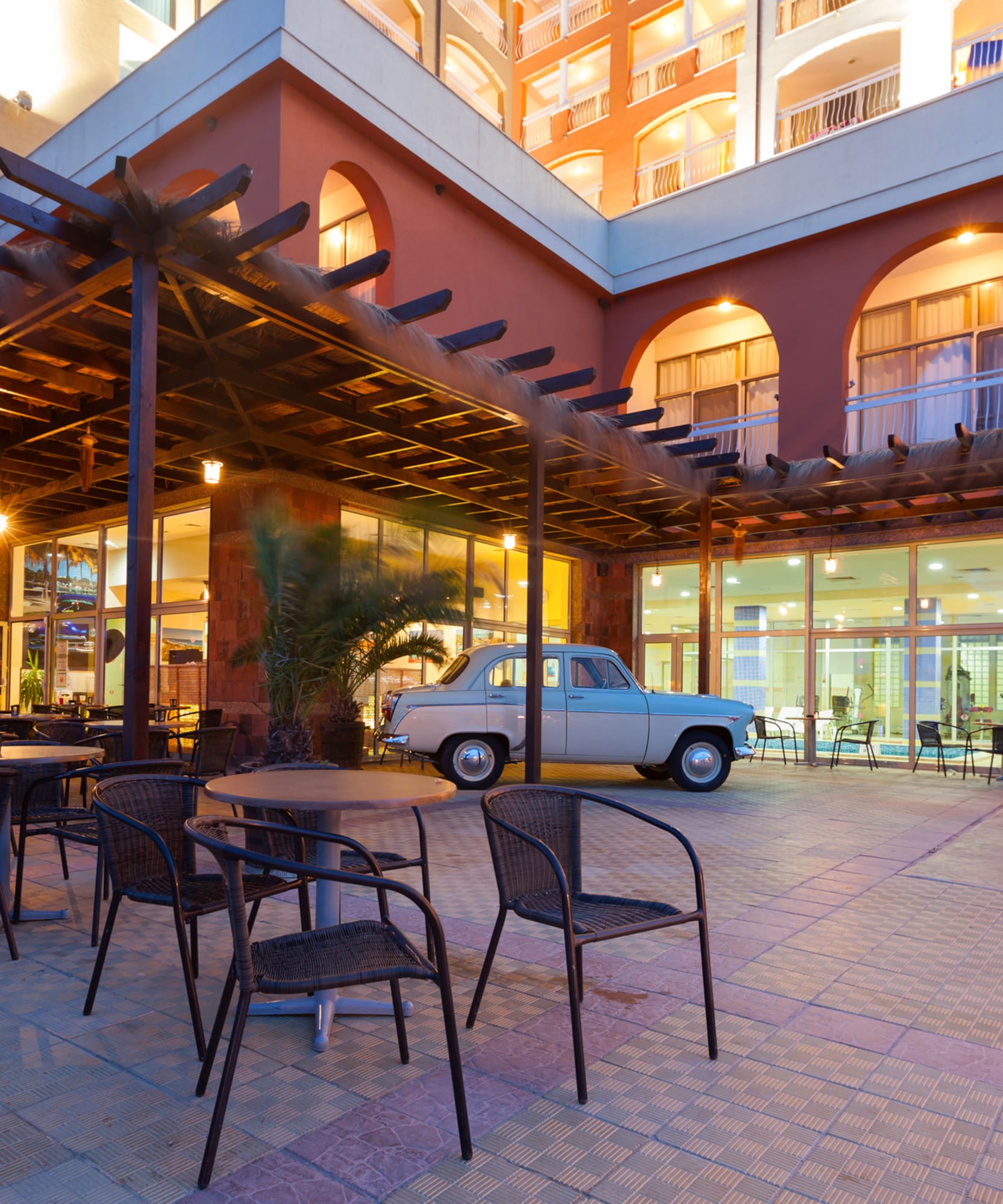 a patio with chairs and tables outside a building