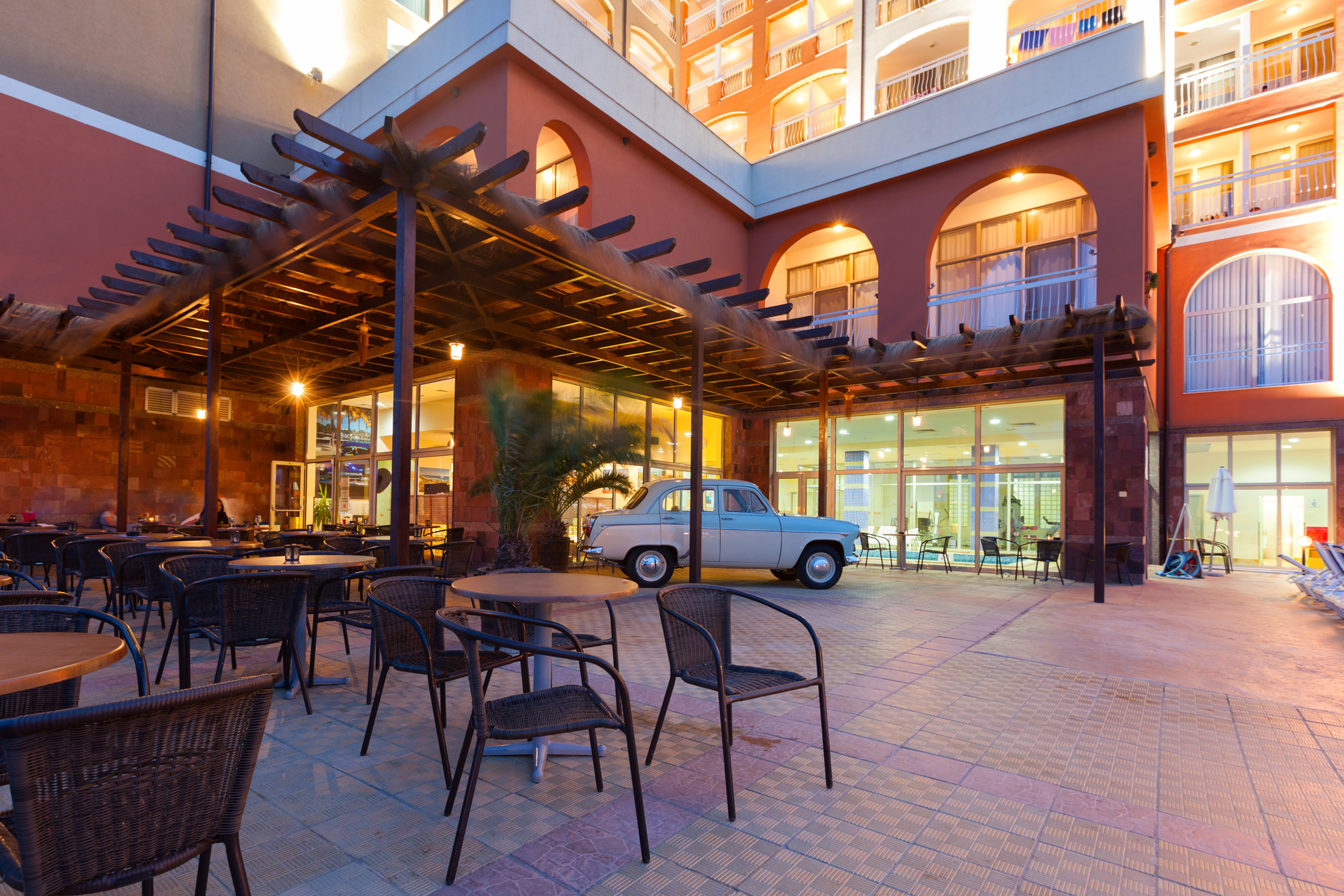 a patio with chairs and tables outside a building