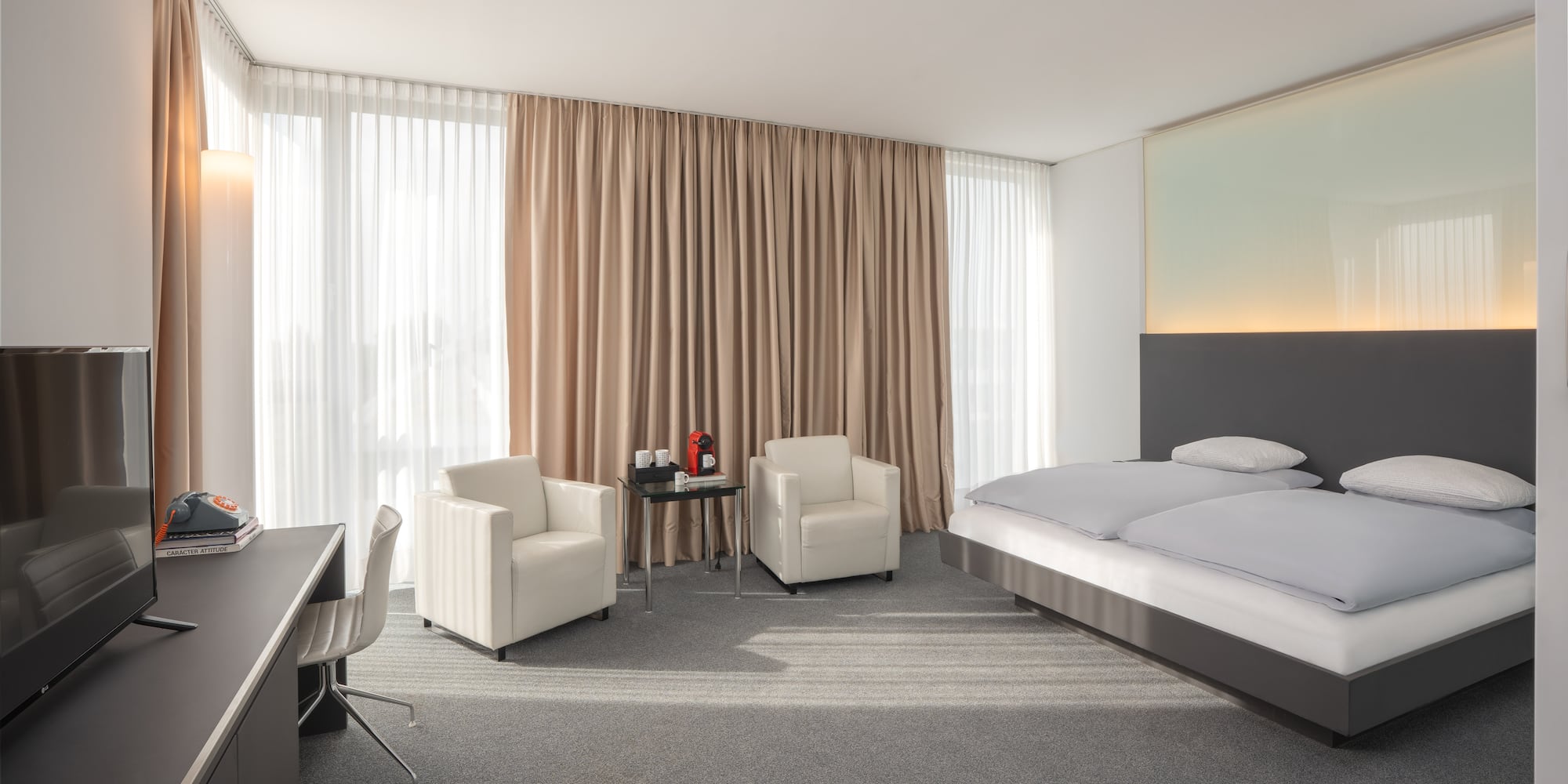 a room with a bed and chairs