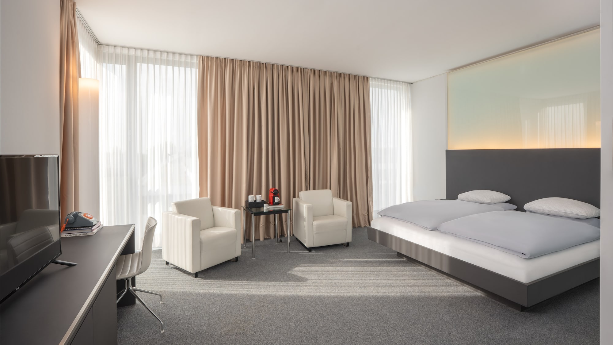 a room with a bed and chairs